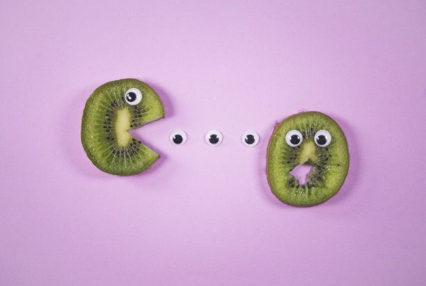 几维鸟切片，玩具眼睛，时尚的软粉色背景图片下载