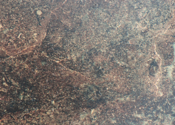 一个平坦的自然深色石头表面与棕色斑点和小坑近距离。图片下载