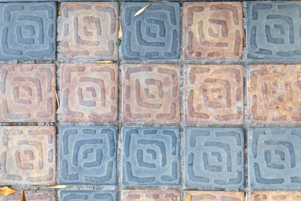 人行道上铺着蓝色和黄色的方形铺路板。砌体结构。图片下载