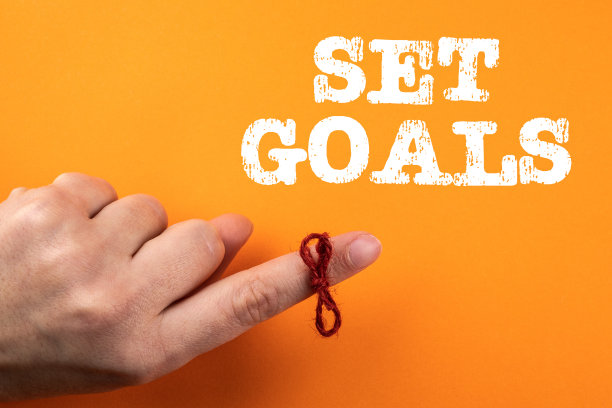 设定目标。在橙色的背景上，手指周围的绳子累了图片下载