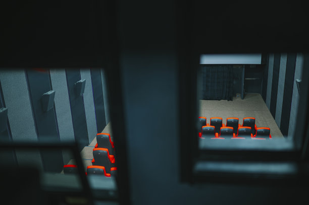 透过放映室窗户顶角看空电影院与空白白色屏幕图片下载