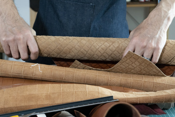 工匠卷起皮革材料图片下载