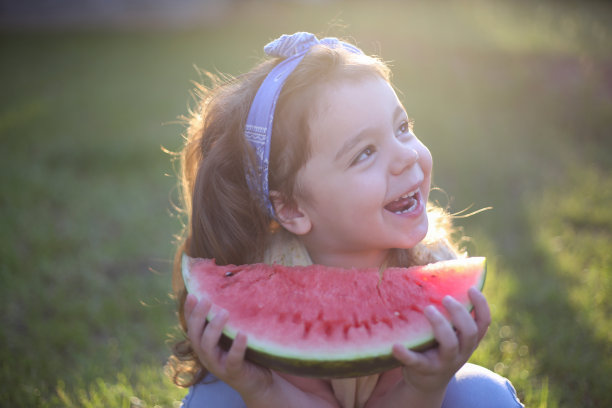 可爱的小女孩在吃新鲜的西瓜水果在花园库存照片图片下载