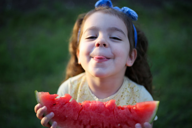 可爱的小女孩在吃新鲜的西瓜水果在花园库存照片图片下载