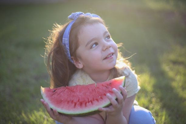 可爱的小女孩在吃新鲜的西瓜水果在花园库存照片图片下载