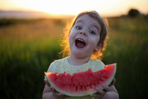 可爱的小女孩在吃新鲜的西瓜水果在花园库存照片图片下载