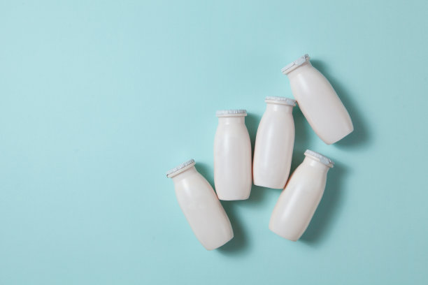 瓶与益生菌和益生元牛奶饮料在浅蓝色背景。图片下载