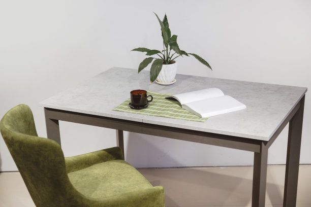 现代极简主义的工作场所。绿色丝绒扶手椅和高架桌，白色盆栽盆栽图片下载