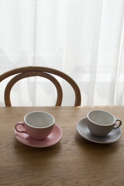 木桌上放着粉红色的空咖啡杯。图片下载