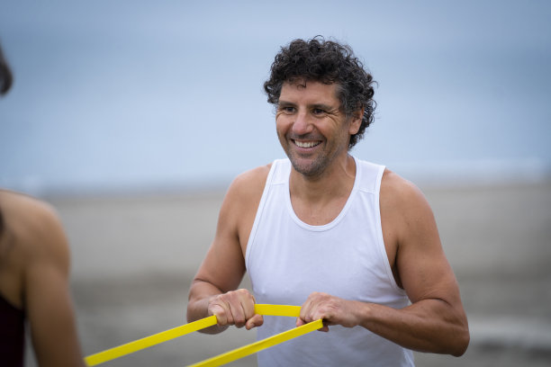 几个运动员在沙滩橡皮筋上锻炼图片下载