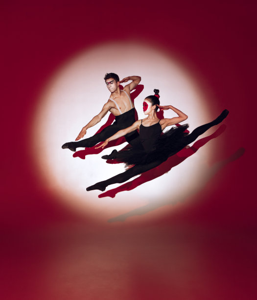 芭蕾舞者在红色的演播室背景上跳舞。现代设计。当代彩色概念光在日本升起的太阳。图片下载