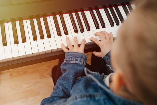 小男孩在家里弹钢琴。模糊，高角度，特写图片下载