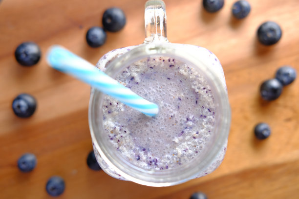 桌上的玻璃杯里有蓝莓奶昔图片下载