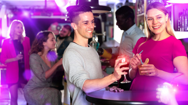微笑的女人和男人在夜店里喝酒图片下载