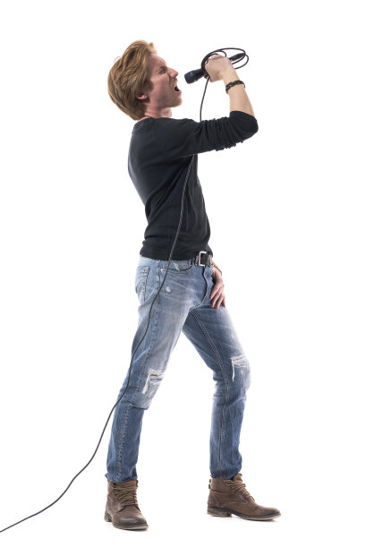 精力充沛的年轻歌手大声歌唱，对着麦克风大喊大叫。图片下载