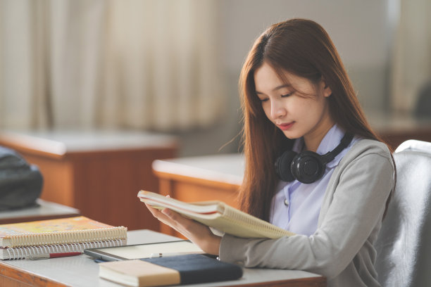 一个年轻的亚洲女大学生在学生制服读书和在教室学习的库存照片图片下载