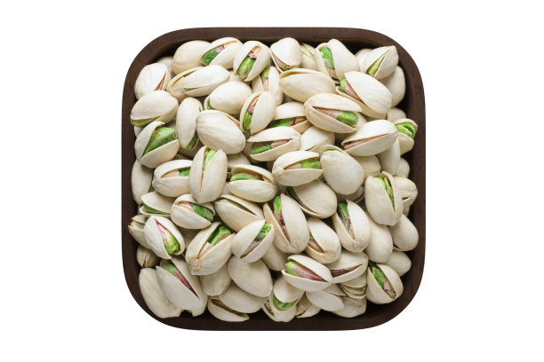 在白色背景上孤立的方形碗中的开心果壳。有机食品，俯视图。图片下载