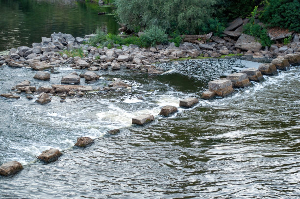 水坝附近河里的石头。照片图片下载
