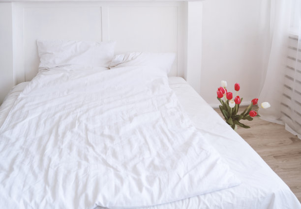 配有白色床和红色室内花的卧室内部图片下载