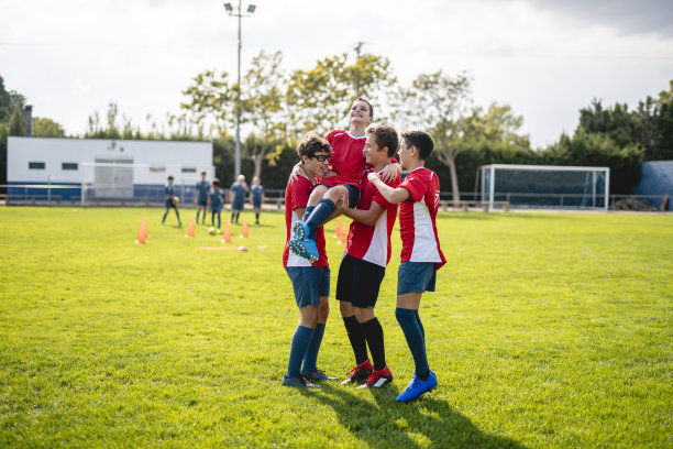 十几岁的男孩足球运动员背着11岁的队友图片下载