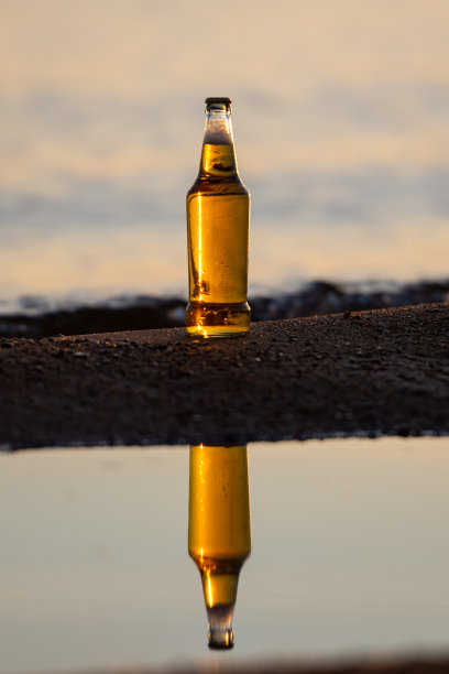 日落时分在海滩上喝啤酒图片下载