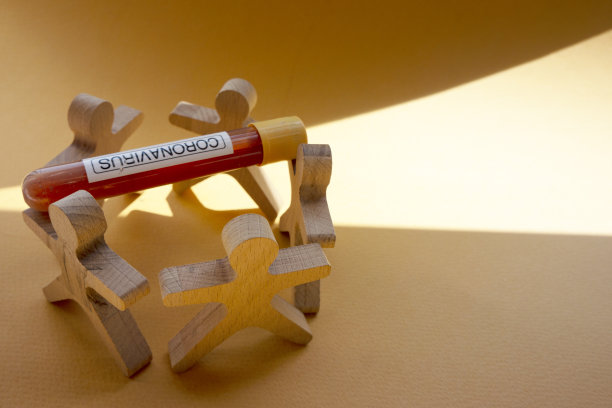 带着试管的木头人。阳光直射下的阴影在黄色的纸背景上。图片下载