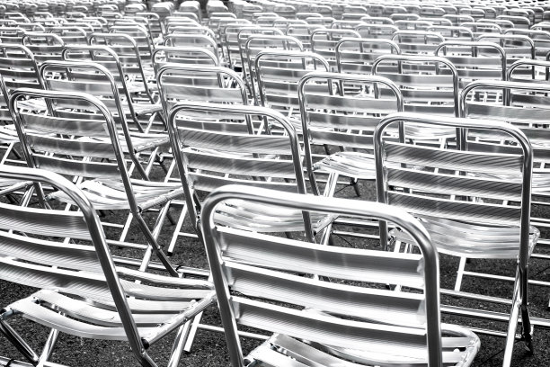 黑色和白色背景的一排排金属椅子。图片下载