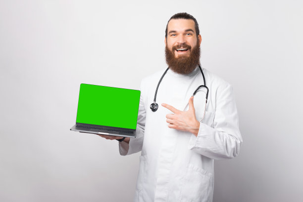 年轻的医生指着笔记本电脑的绿色屏幕图片下载