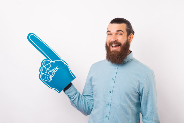 嘿，看看这个，英俊的，快乐的胡子男人，穿着随意，戴着扇子手套指着远方图片下载