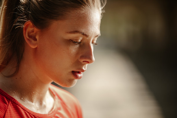 近距离的照片运动金发女人出汗休息从锻炼。图片下载