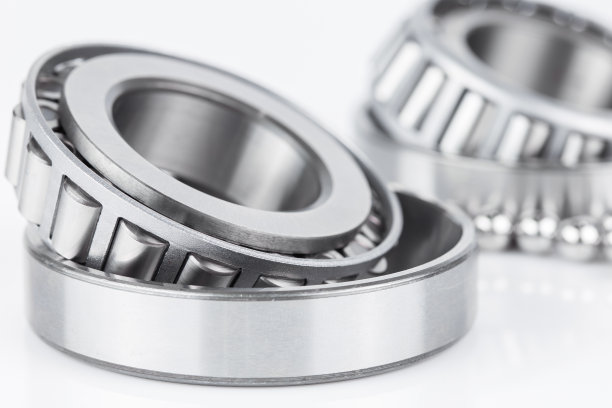 在白色背景上的圆锥滚子轴承备件的特写。图片下载