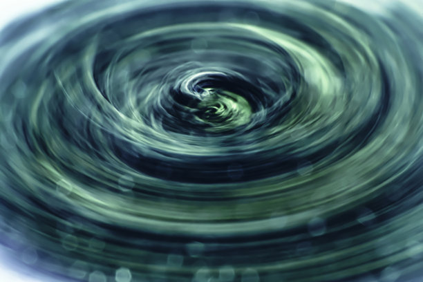 摘要模糊背景与旋转湍流涡。高光泽的海蓝色的幻灯片覆盖与闪烁的反射阴影。图片下载