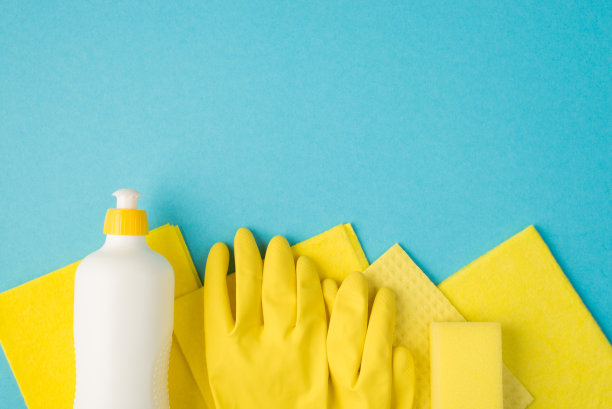 上面的照片，肥皂清洁抹布和黄色手套孤立在蓝色背景图片下载