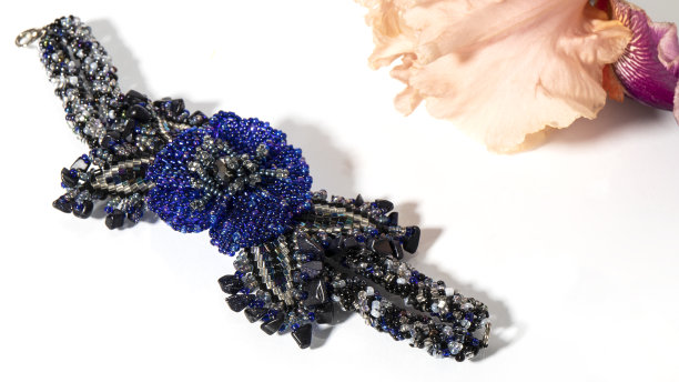 美丽的深蓝色手镯，由天然宝石和闪闪发光的珠子在白色的背景。图片下载