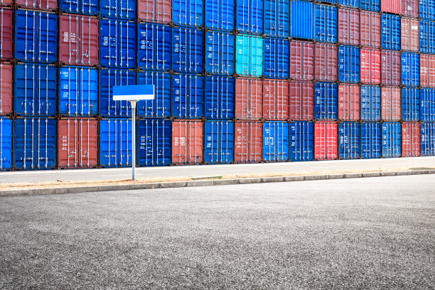 堆叠的货物集装箱和空旷的沥青路面景观图片下载