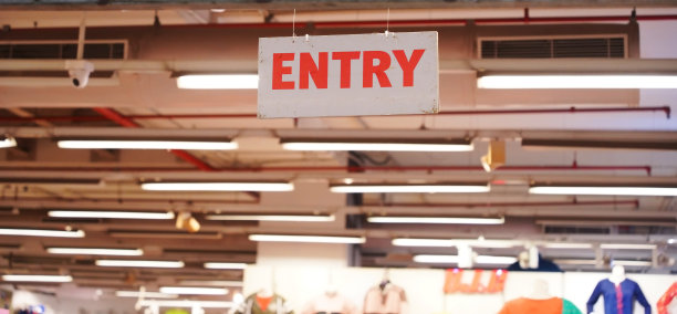 一家服装店的白色标志上用红色的字母拼写“entry”图片下载