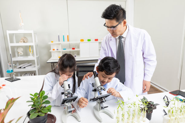 科学教师在实验教室帮助或教学生如何使用显微镜图片下载