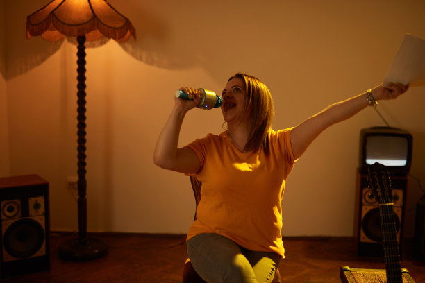 一个女人在复古的房间里用无线麦克风播放音乐和唱歌。图片下载