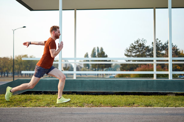年轻的运动女性在城市公园伸展和锻炼。图片下载