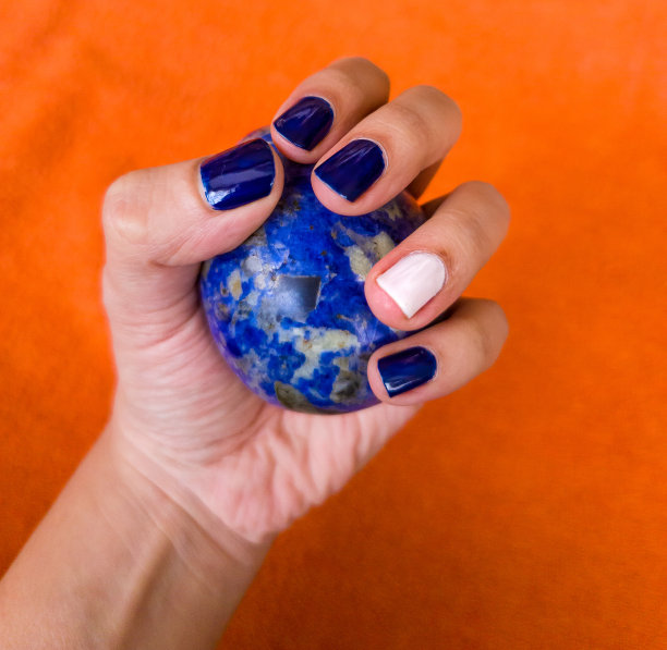 手拿着一块卵形的钠铝石图片下载