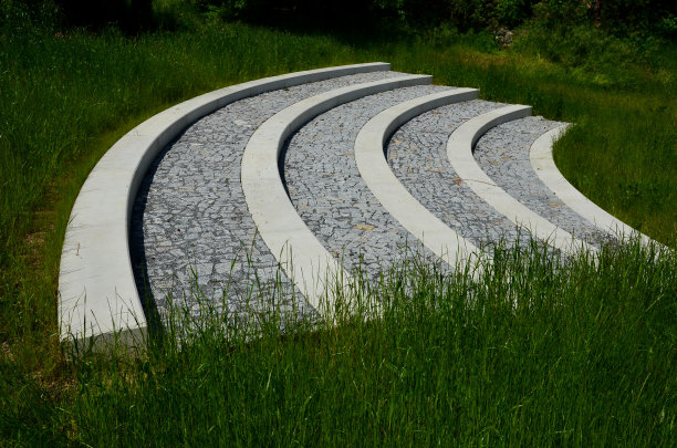 论坛广场在公园里由灰色的花岗石制成的混凝土楼梯变成一个拱形草地的中央。路边作为座位环绕着木制凉亭。图片下载