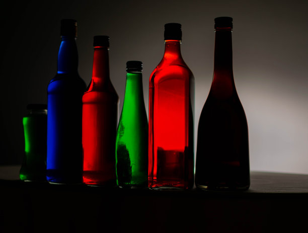 液体颜色在瓶子上有各种颜色的背景。光的效果。用作背景、广告、装饰或壁纸。图片下载
