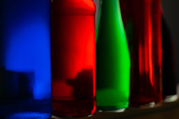 液体颜色在瓶子上有各种颜色的背景。光的效果。用作背景、广告、装饰或壁纸。图片下载