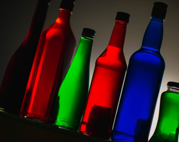液体颜色在瓶子上有各种颜色的背景。光的效果。用作背景、广告、装饰或壁纸。图片下载