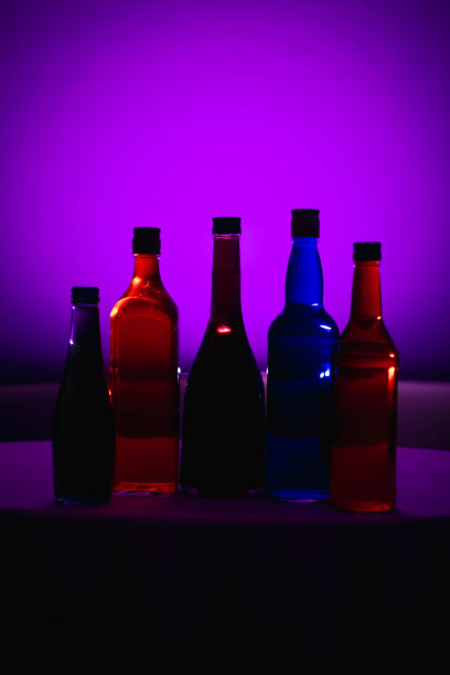 液体颜色在瓶子上有各种颜色的背景。光的效果。用作背景、广告、装饰或壁纸。图片下载