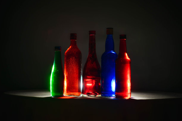 液体颜色在瓶子上有各种颜色的背景。光的效果。用作背景、广告、装饰或壁纸。图片下载