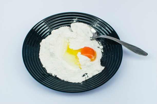 黑色盘子与鸡蛋和面粉存货照片图片下载