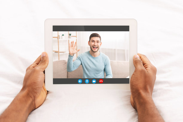 一个面目全非的男人躺在床上，用平板电脑和朋友视频聊天图片下载