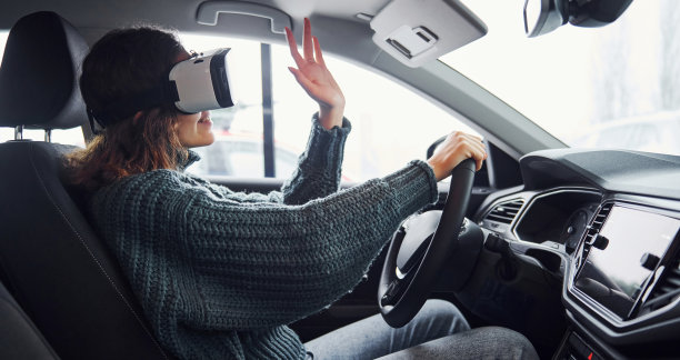 戴着虚拟现实眼镜坐在现代汽车里的女人的侧视图图片下载