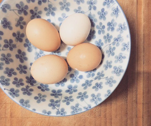 4个鸡蛋靠近放置在带有木制背景的日本花图案的碗里图片下载